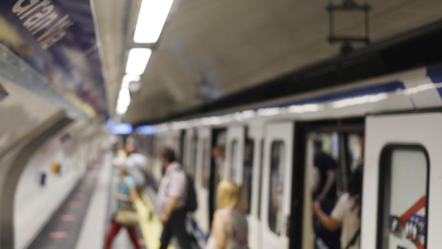 Varias personas salen de un vagón en la estación de metro de Gran Vía, en Madrid.