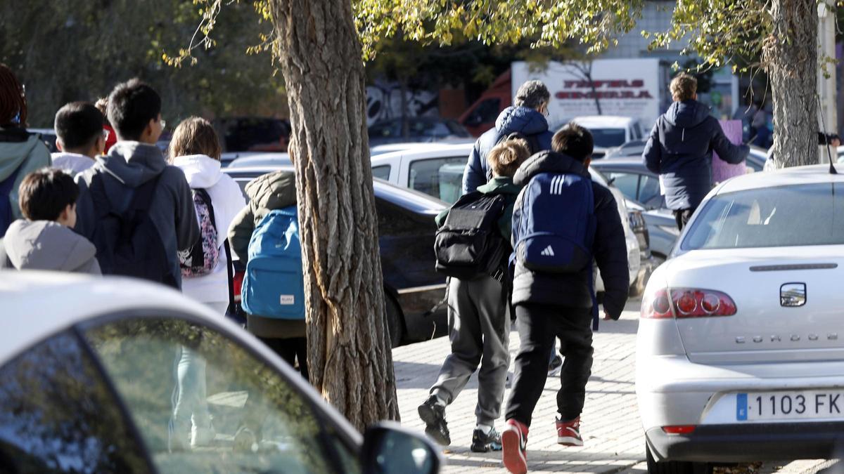 Varios jóvenes del Grande Covián persiguen al profesor condenado por malos tratos a la salida de clase.