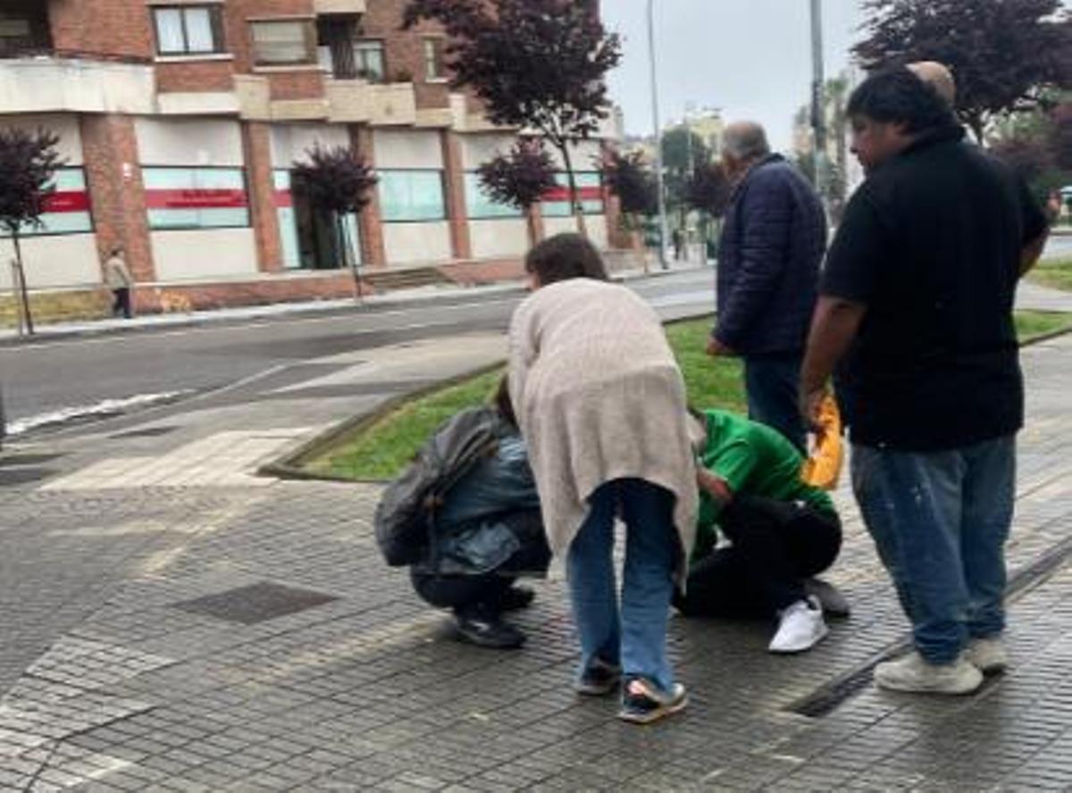 Uns vianants atenen el ferit abans de l'arribada de l'ambulància.