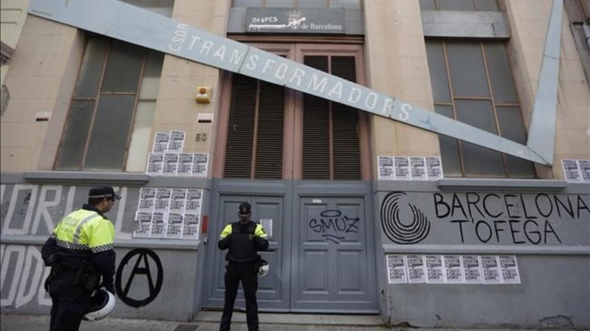 Dos guardias urbanos en la puerta del edificio Transformadors, tras el desalojo.