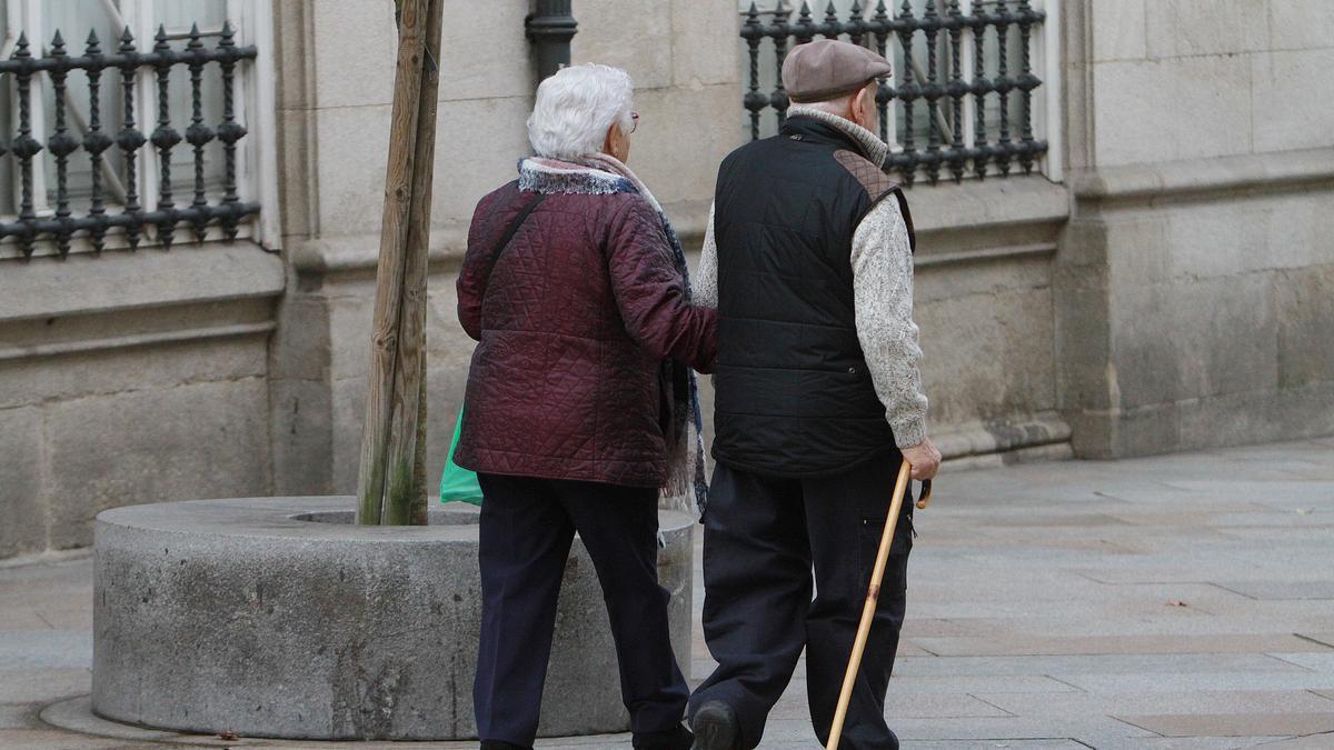 Una pareja de jubilados pasea por la calle