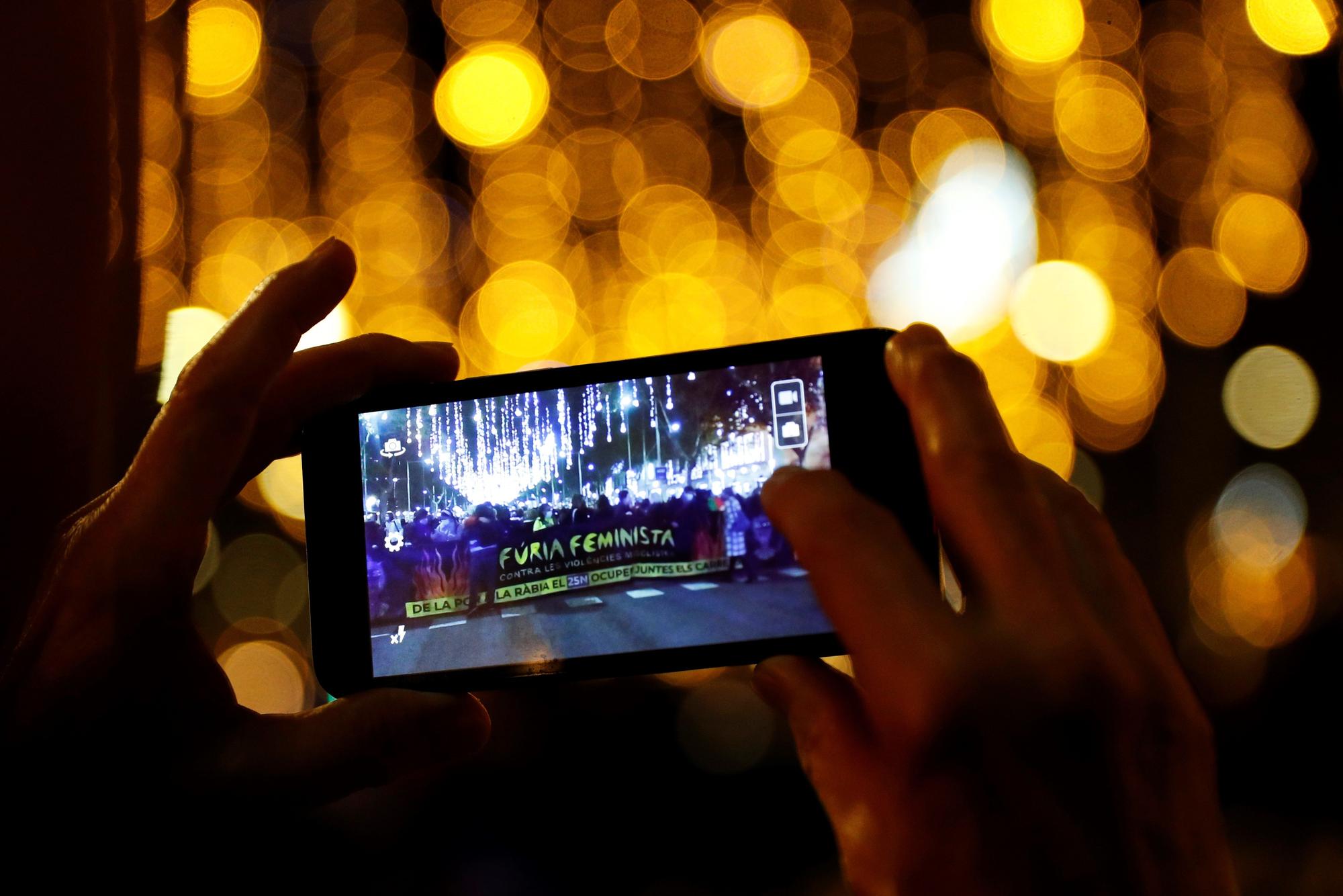 Un asistente fotografía la cabecera de la manifestación feminista con motivo del 25N, Día Internacional para la Eliminación de la Violencia contra la Mujer, este jueves bajo el lema &quot;Furia feminista contra las violencias machistas&quot;, en Barcelona.