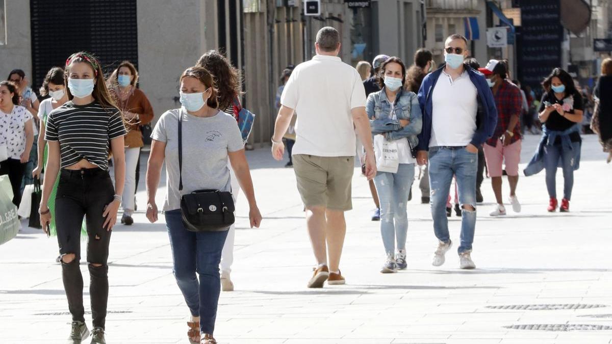 Gente con mascarilla por el centro de la ciudad de Vigo. // José Lores