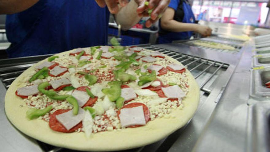 Un cocinero prepara una pizza.