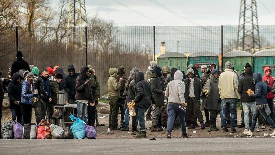 Inmigrantes ilegales hacen cola para recibir comida en Calais.