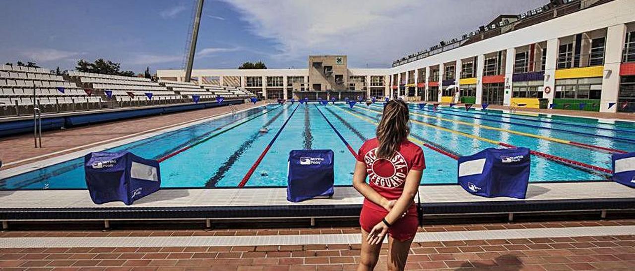 Dos nadadores caminando junto a la piscina exterior de 50 metros del polideportivo de Son Hugo. Arriba, el gerente, Rafel Navarro.