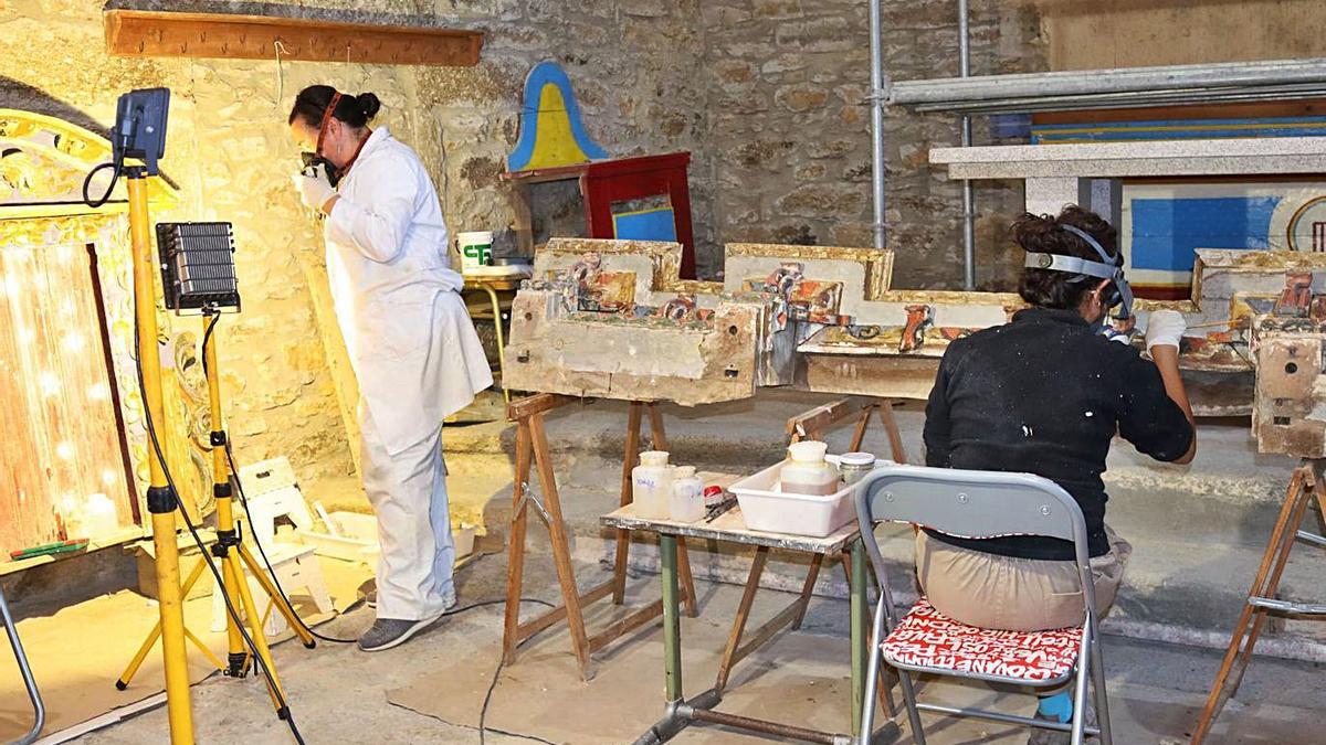 Las restauradoras Ana Prieto y Carmen García realizando trabajos de reatauración del retablo.|