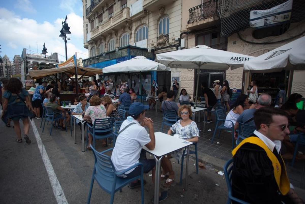 Un local en la calle Xàtiva con todas las mesas ocupadas, pero sin la multitud de gente de otros años. | FERNANDO BUSTAMANTE