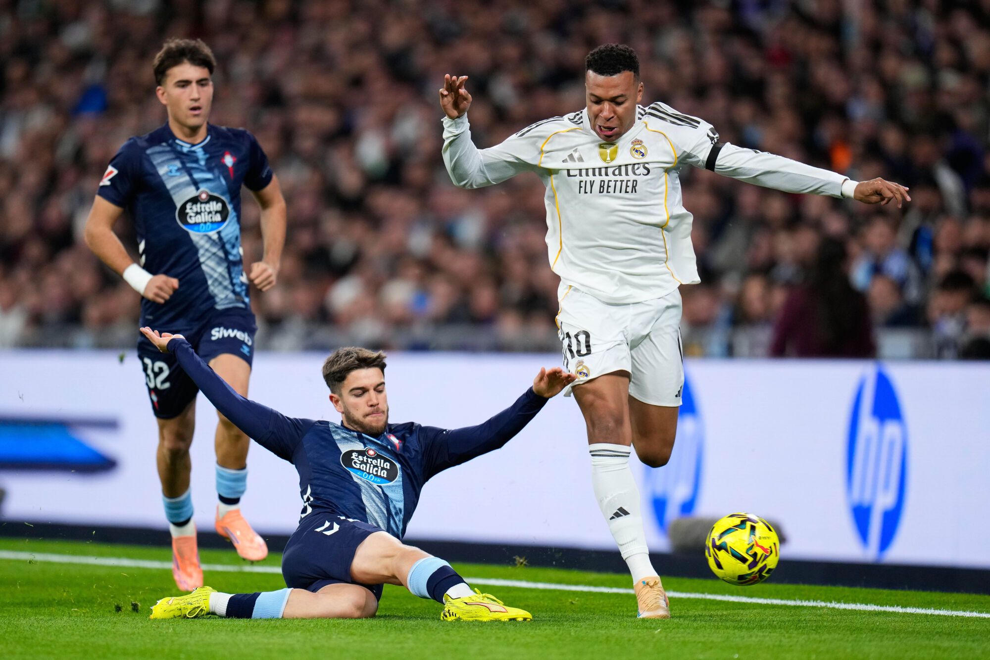 Real Madrid's Kylian Mbappe is challenged by Celta's Sergio Carreira during the Spanish La Liga soccer match between Real Madrid and Celta Vigo in Madrid, Spain, Sunday, Dec. 7, 2025. (AP Photo/Manu Fernandez). EDITORIAL USE ONLY / ONLY ITALY AND SPAIN