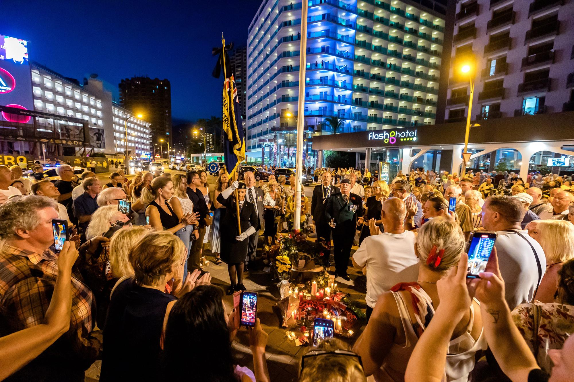 Británicos residentes y turistas de Benidorm rinden un sentido homenaje a Elizabeth II en el espacio habilitado por el Ayuntamiento en la zona inglesa de la ciudad.