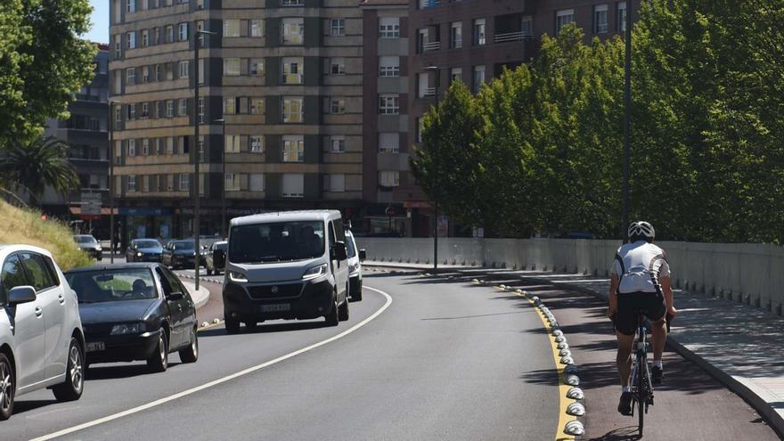 Un ciclista y varios vehículos, en uno de los accesos a Pola de Siero.