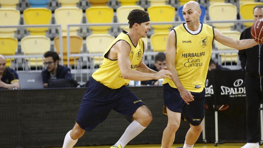 Kyle Kuric sonríe mientras defiende a Albert Oliver -con el balón- bajo la mirada de Aíto García Reneses.