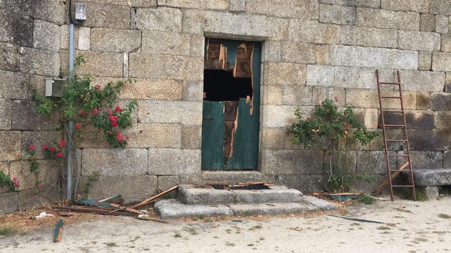 Destrozos en la puerta por la que accedieron los ladrones. // A. C.