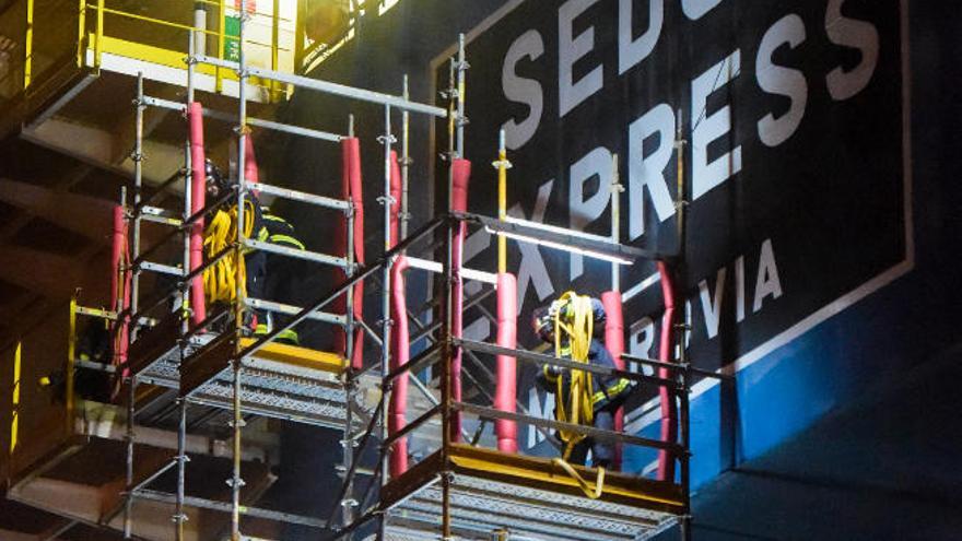 Los bomberos en la escalera de acceso a la &#039;Sedco Express&#039;.