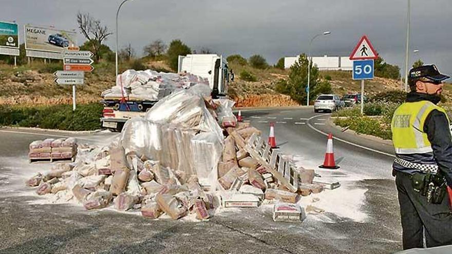 Un policía junto al camión y los sacos de cemento que perdió, ayer en el Camí de Jesús, en Palma.