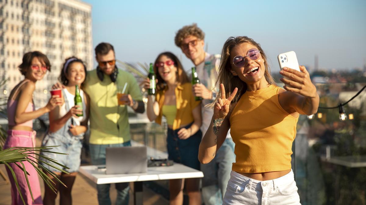 Un grupo de jóvenes, haciéndose una fotografía con un móvil.