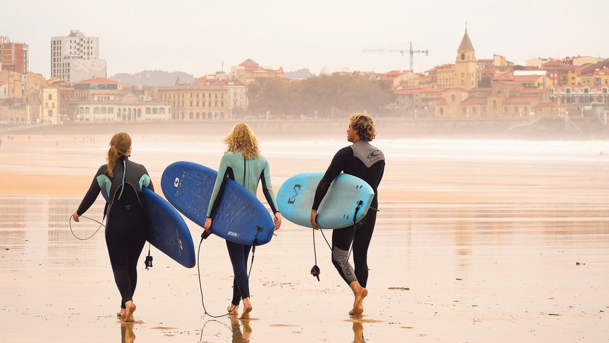 Surfistas en la playa de San Lorenzo de Gijón