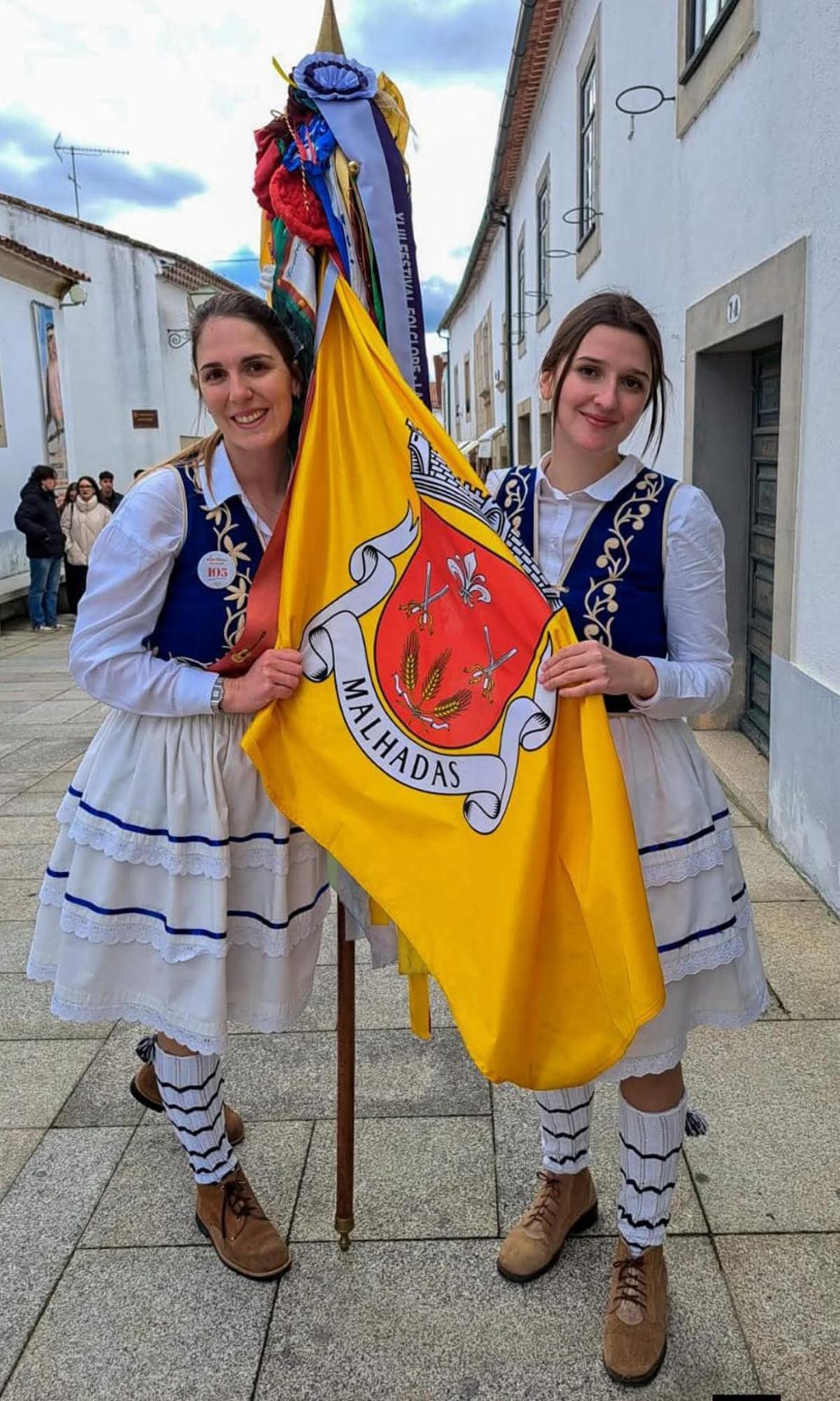 Mujeres con el traje típico muestran la bandera de Malhadas (Miranda). | CH. S.