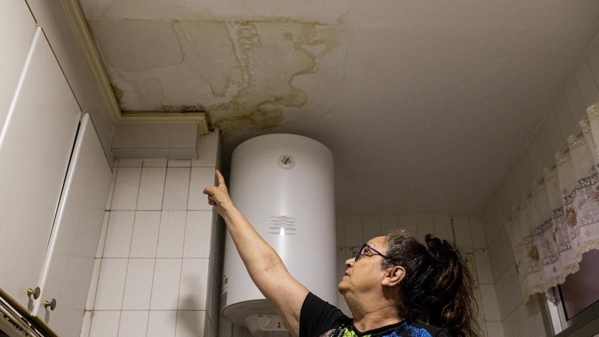 Agustina López, residente en el Bloque B del barrio cacereño de Aldea Moret, señala la humedad y las pésimas condiciones en las que se encuentra la cocina de su domicilio.