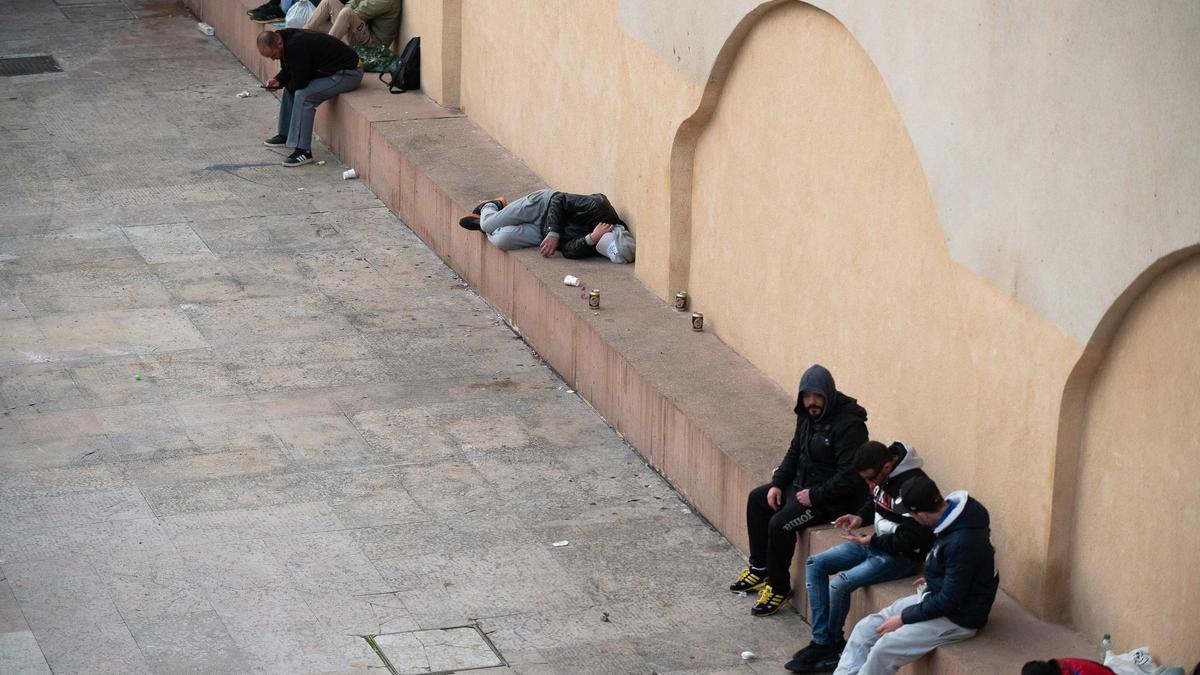 Personas, algunas de ellas usuarias del albergue, beben en el patio lateral del Centro de Historias.