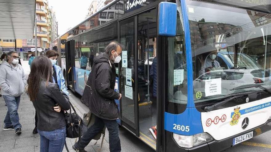 Viajeros subiendo ayer a un autobús en la parada de la calle Jardines.