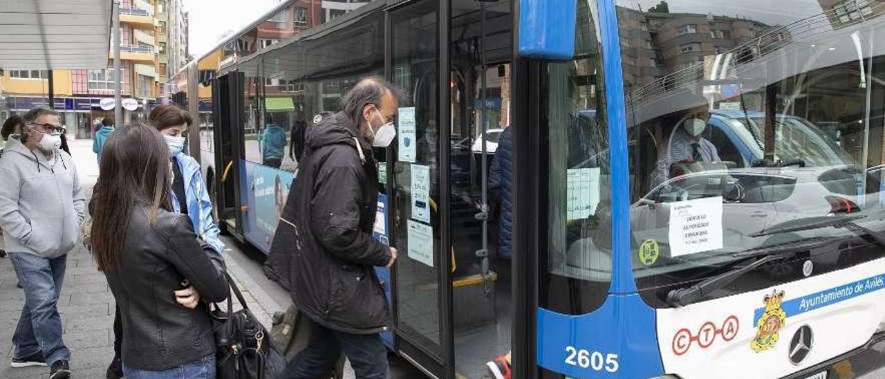 Viajeros subiendo ayer a un autobús en la parada de la calle Jardines.