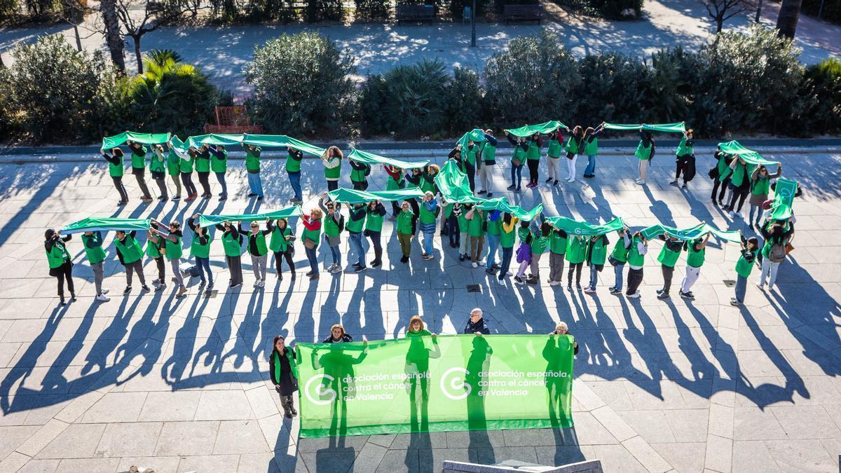 Lazo humano realizado esta mañana en el cauce del río Túria para visibilizar el apoyo contra el cáncer de AECC Valencia.