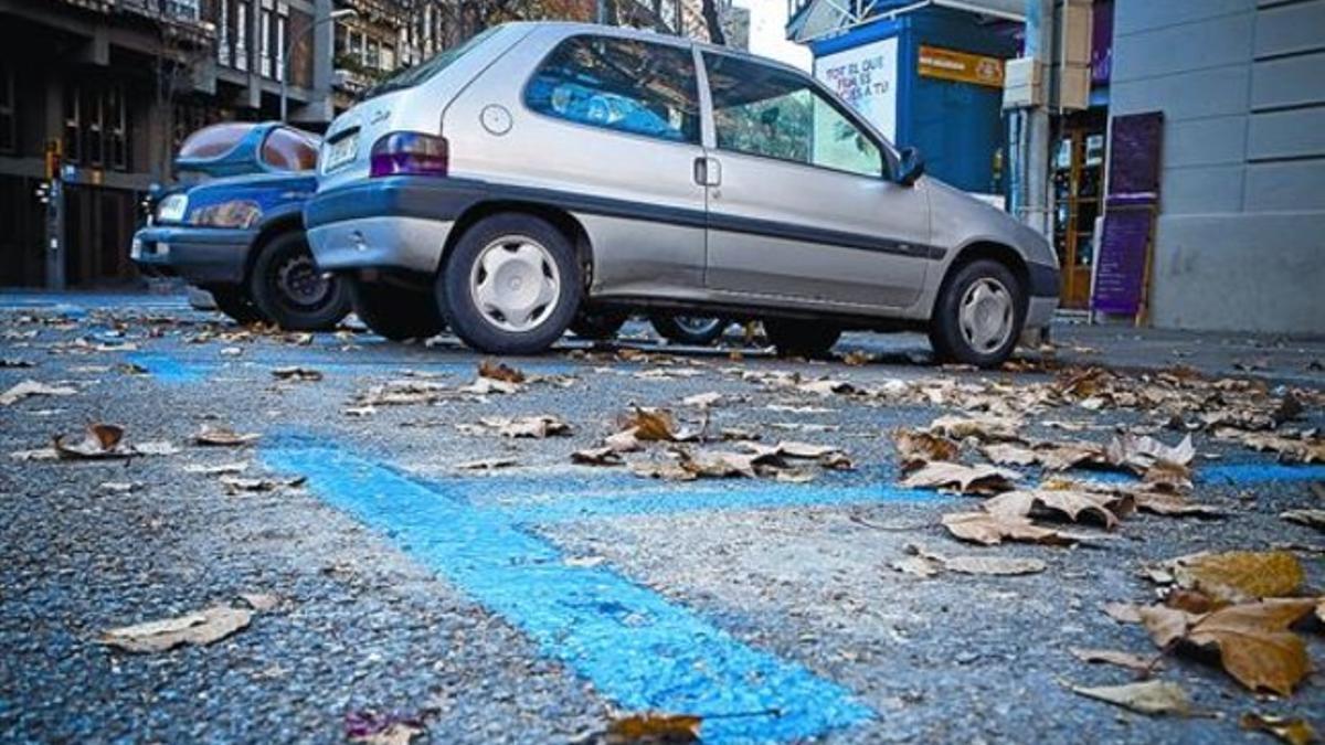 Turismos aparcados en un área azul del Eixample, el día de Sant Esteve.