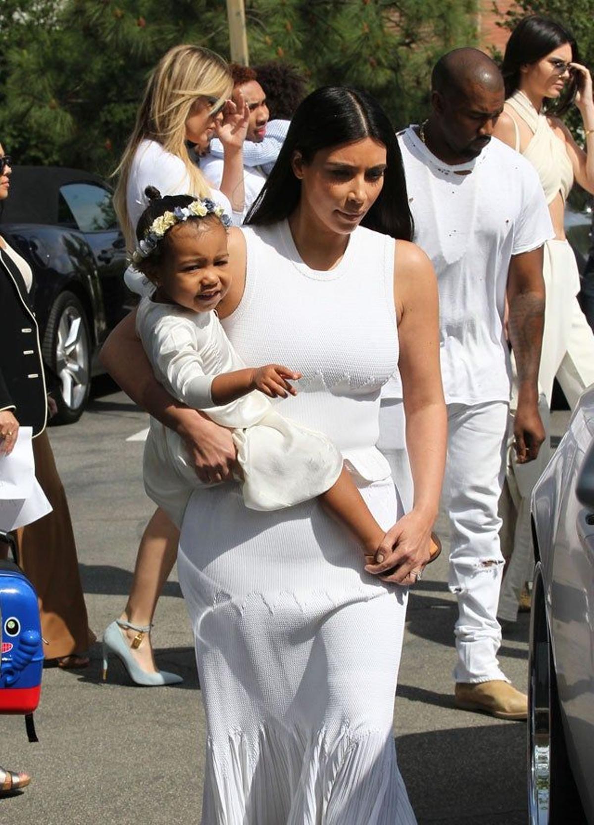 Kim Kardashian lleva en brazos a su hija Nori, ambas vestidas de blanco