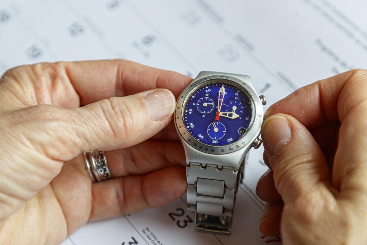 Imagen de archivo de un usuario cambiando de hora el reloj tras un cambio horario. EFE/ Javier Belver