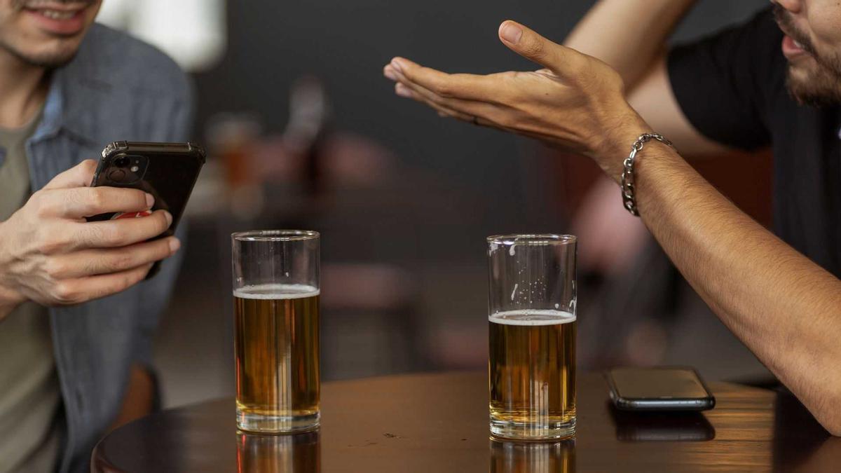 Un parell de persones conversen a l'interior d'un bar, en una imatge d'arxiu.
