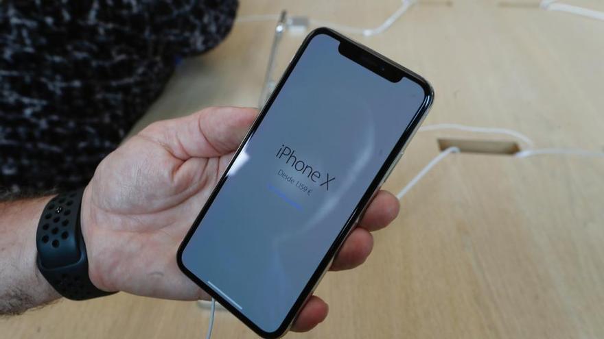 Un hombre sostiene un iPhone X.