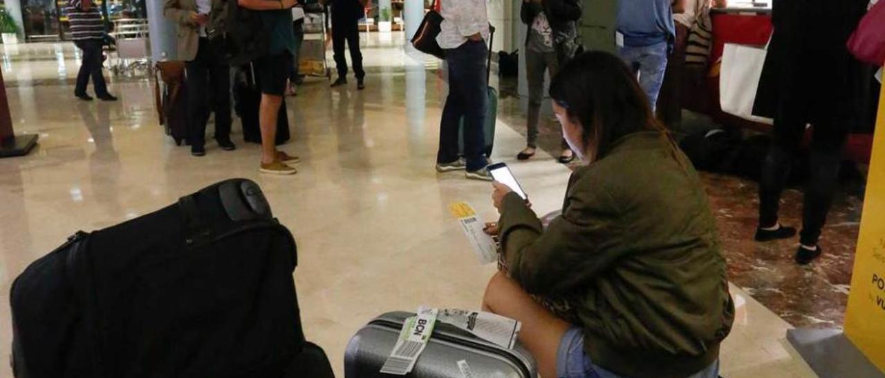 Pasajeros del vuelo a Barcelona retrasado hasta la madrugada de ayer, en el aeropuerto de Asturias.