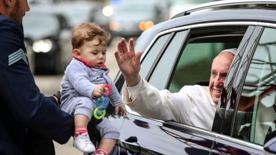 El Papa beneeix un nen en la seva visita a Portugal.