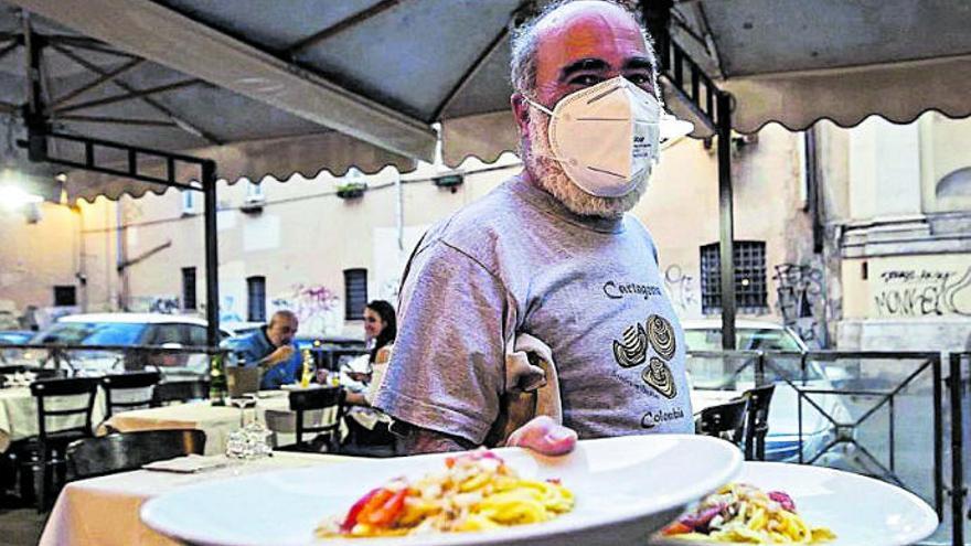 Un camarero sirve pasta en un restaurante de Roma.