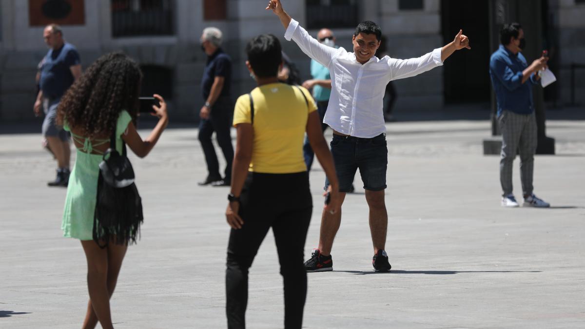 Un turista se hace una foto en la Puerta del Sol.