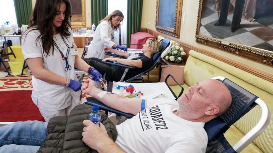 Rocío Suárez ayuda a donar a Marcos Martín, ayer, en el salón de recepciones del Ayuntamiento.