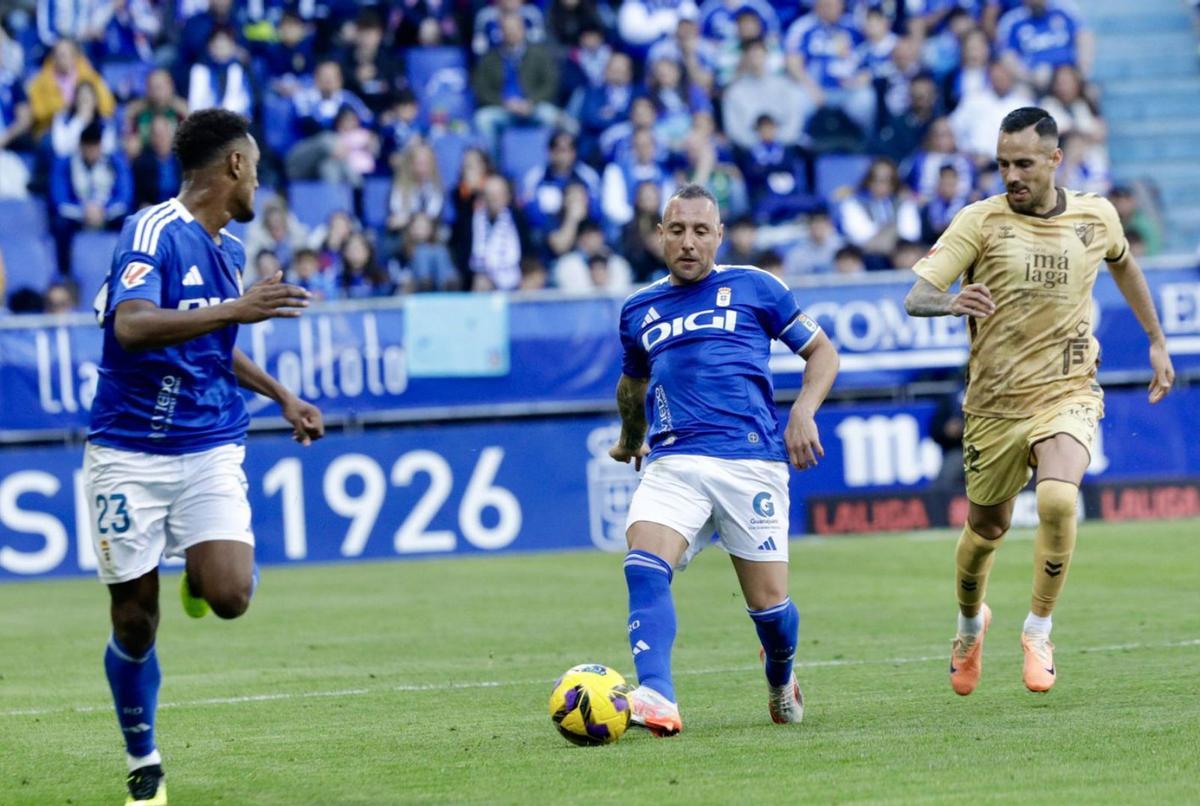 Cazorla dando un pase a Hassan ante Manu Molina, anteayer, en el Tartiere. | JUAN PLAZA