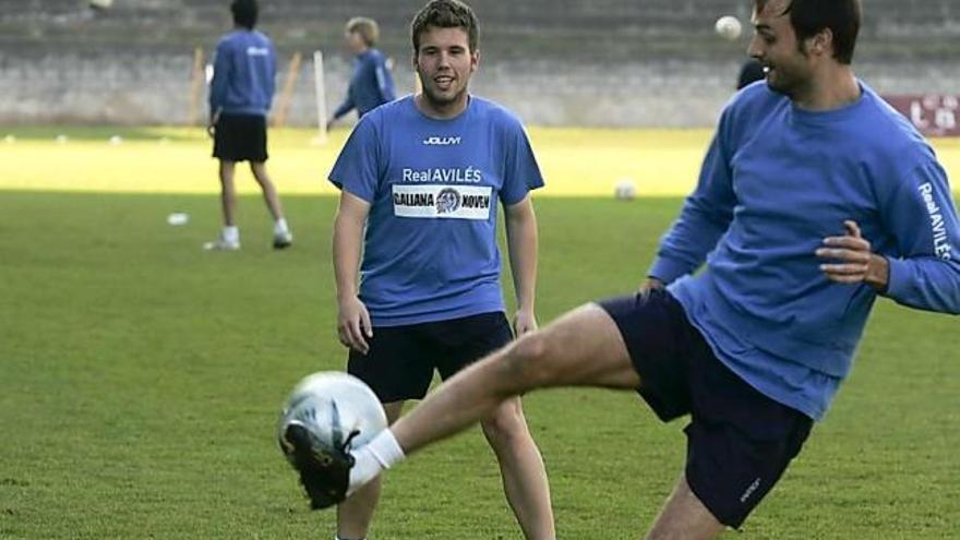 Salva, tocando el balón, y Sergio, durante el entrenamiento de ayer, con Marcos y Enol al fondo.