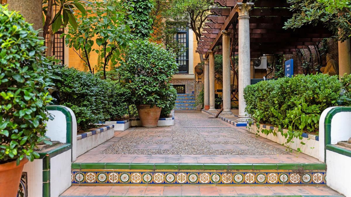 Uno de los rincones del jardín con un porche de madera donde el artista se refujiaba los días de sol