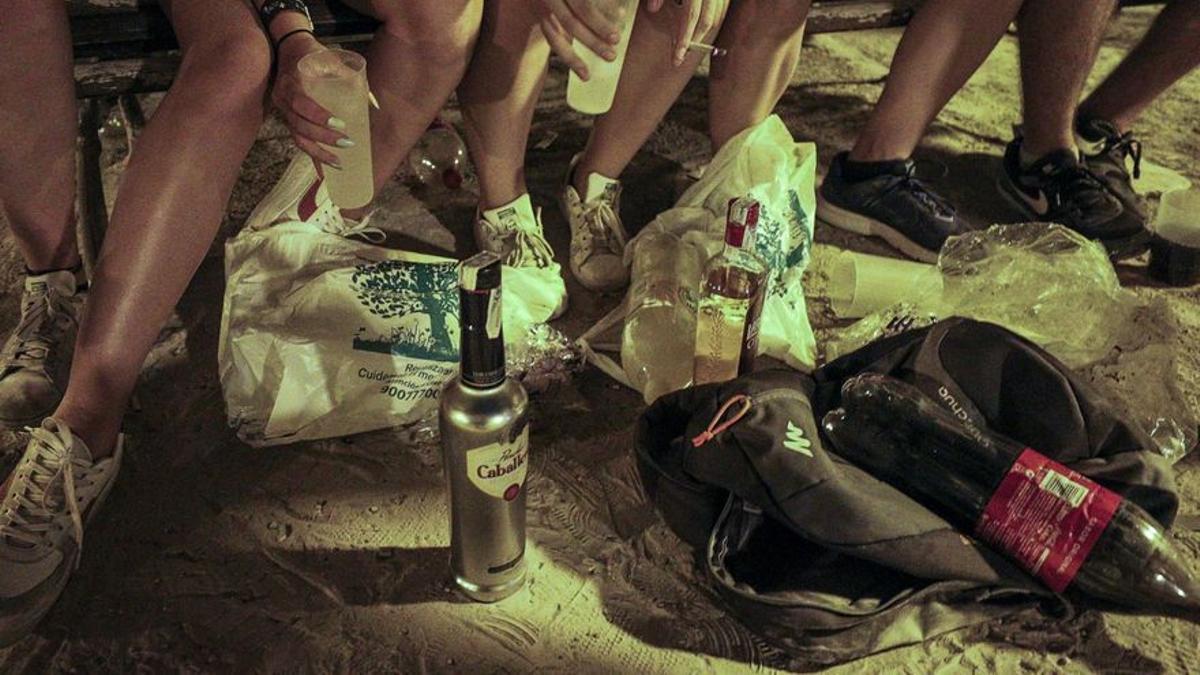 Un botellón en una playa.