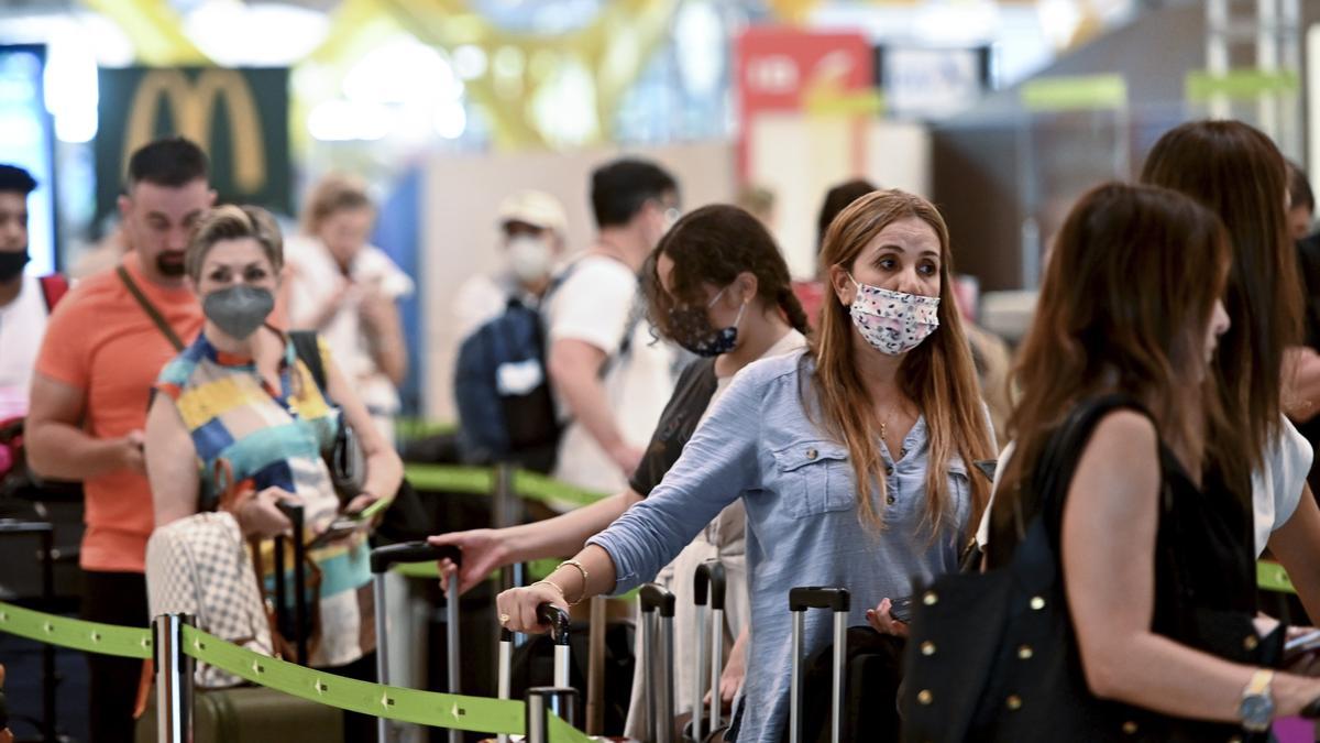 Una mujer con mascarilla en un aeropuerto.