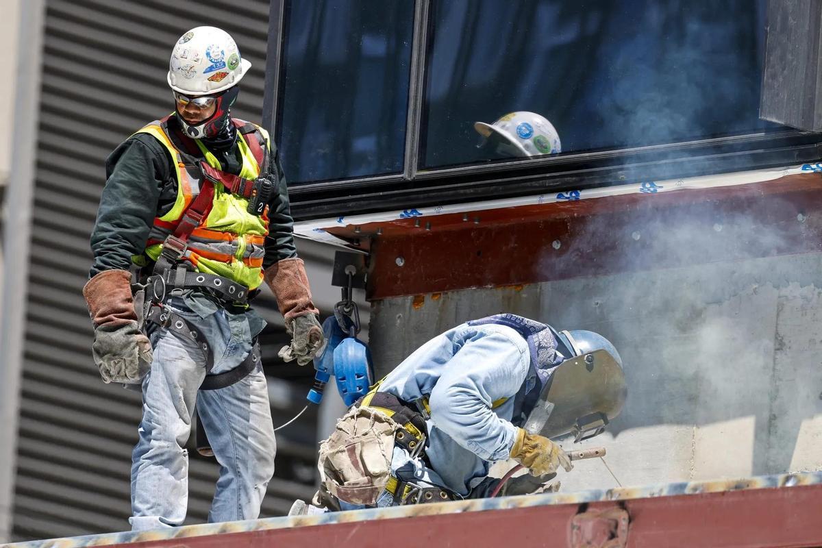 Trabajadores con equipos de protección en una obra, en una imagen de archivo.