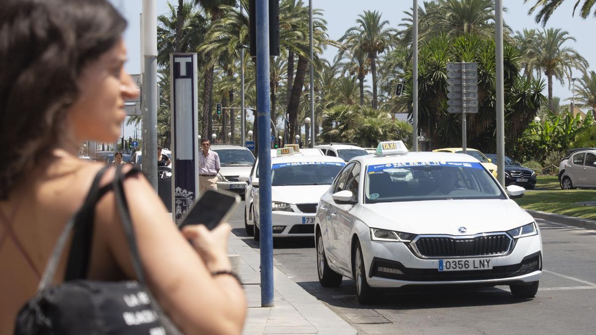 Una joven espera para subir a un taxi en Alicante en una imagen reciente.