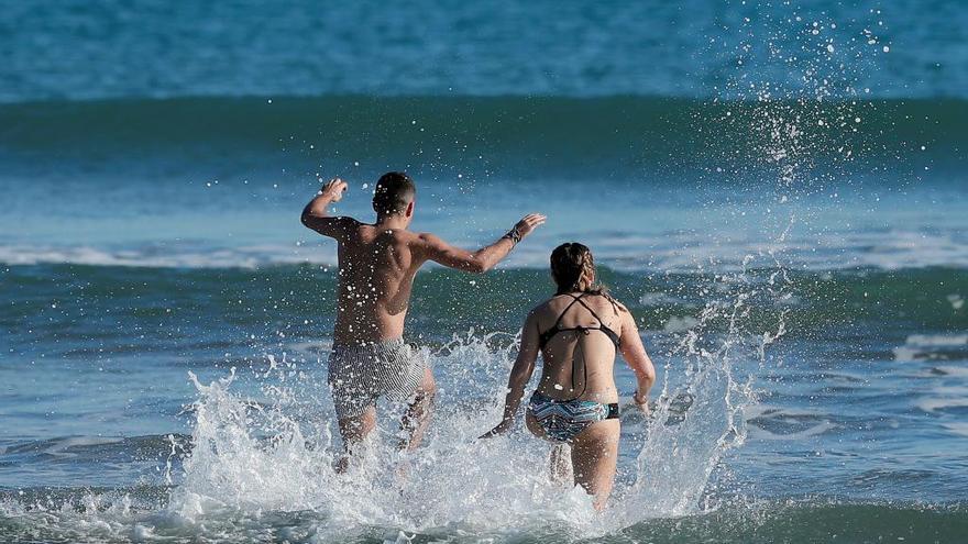 Una pareja se baña en la playa de la Malva-rosa el día de Nochebuena.