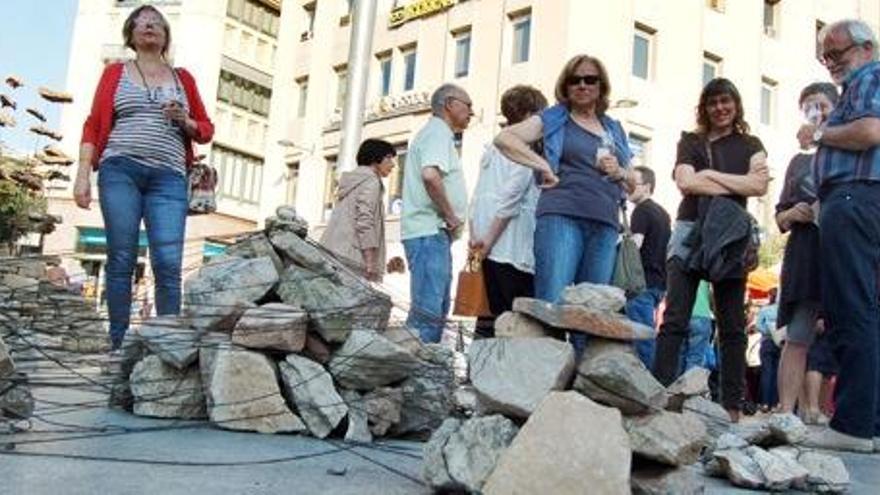 Uns vianants contemplen l&#039;escultura &quot;Fites&quot;, de l&#039;artista Alèxia Lleonart