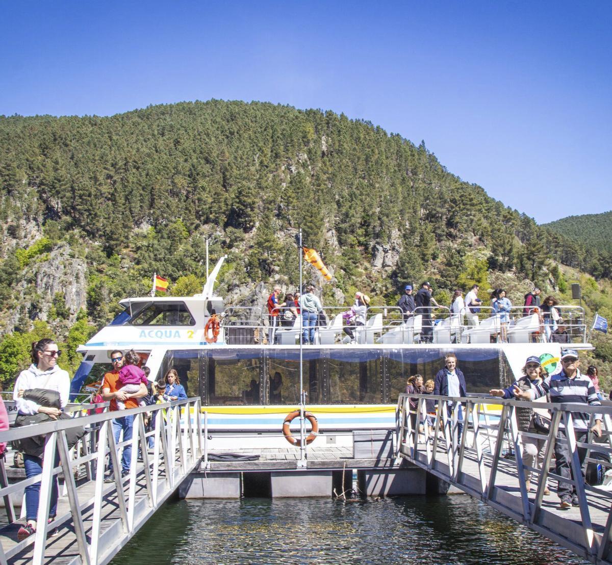 Los turistas desembarcan en Santo Estevo de uno de los catamaranes llenos.