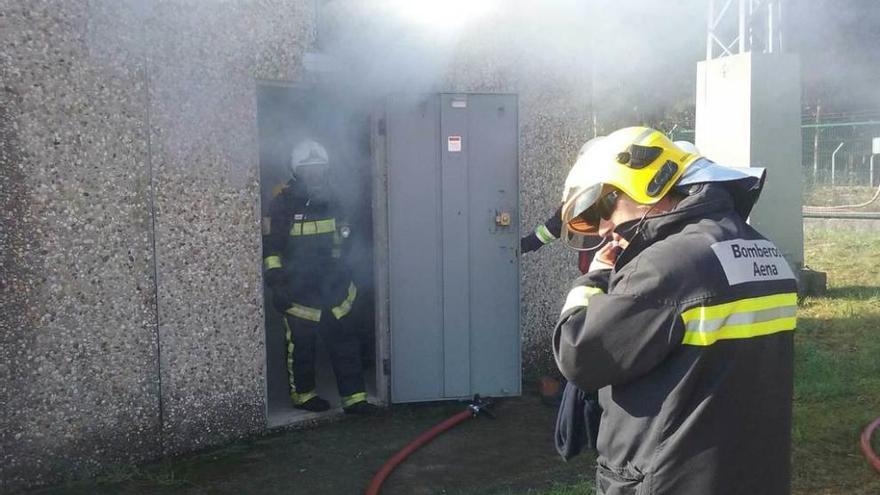 Ejercicio de emergencia en el Aeródromo. Arriba, los bomberos acceden a la estación eléctrica donde se simuló un incendio; sobre estas líneas, los bomberos, tras apagar el fuego.