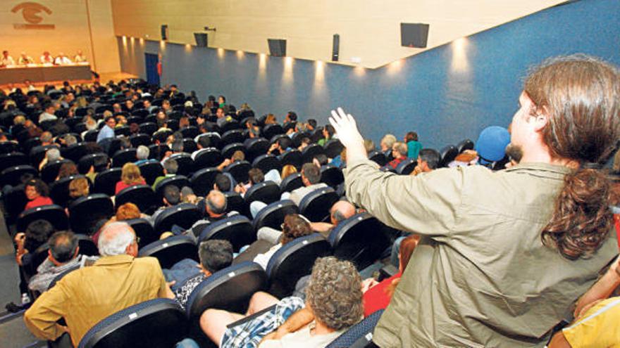 Uno de los asistentes formula una pregunta a la mesa de debate ante la sala del Club INFORMACIÓN que se llenó de público.