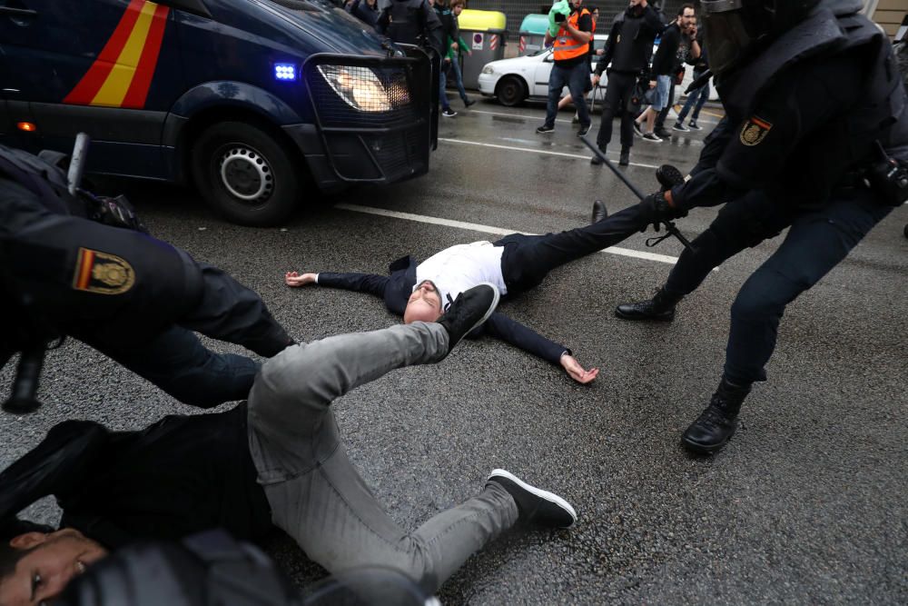 Forcejeo entre la Policía Nacional y varios manifestantes que acaban en el suelo.